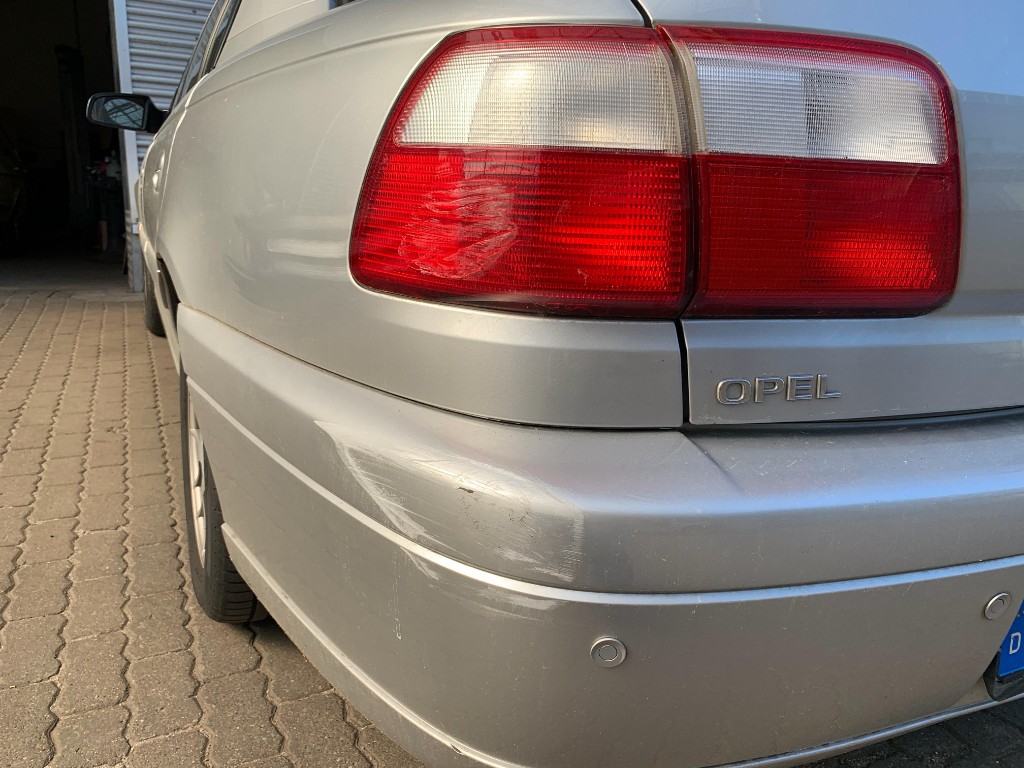Heckschaden an silbernem Opel – Rücklicht gesprungen, Heckstoßfänger eingedrückt